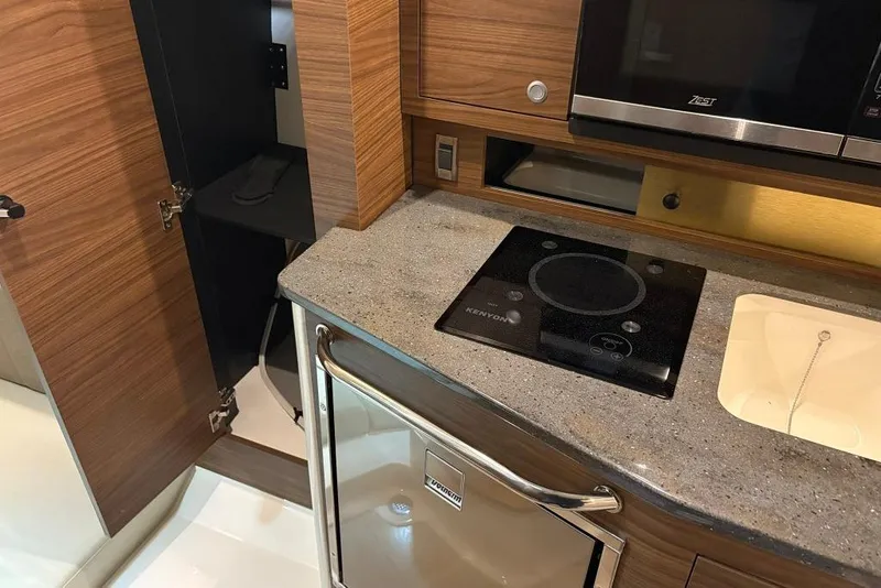 Slide: The Image of 2022 Boston Whaler 325 Conquest kitchen with stove, sink, and microwave. - 36