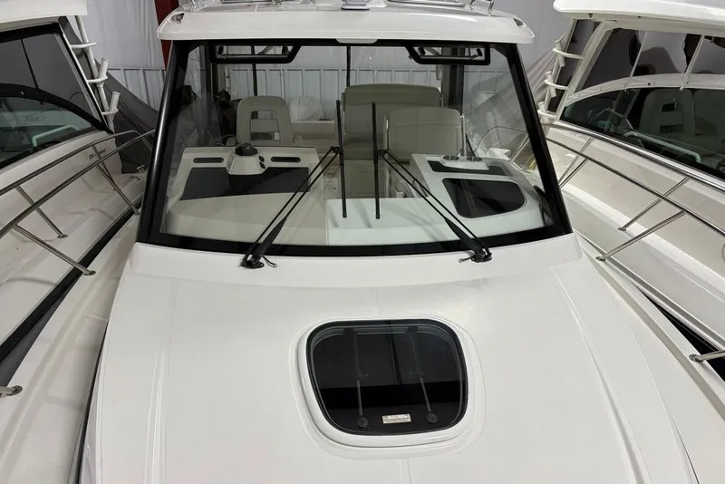 Slide: The Image of 2022 Boston Whaler 325 Conquest boat interior with windshield and seating area. - 48