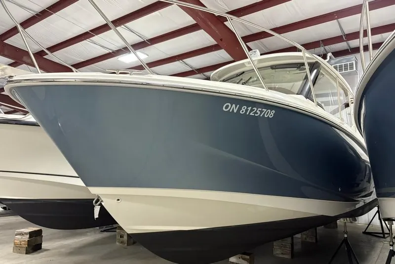 Slide: The Image of 2022 Boston Whaler 325 Conquest boat in storage, blue hull, indoor facility. - 5