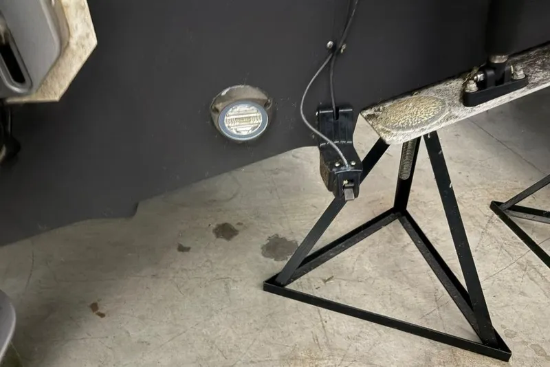 Slide: The Image of 2022 Boston Whaler 325 Conquest boat on stands, showing hull and underwater light. - 51