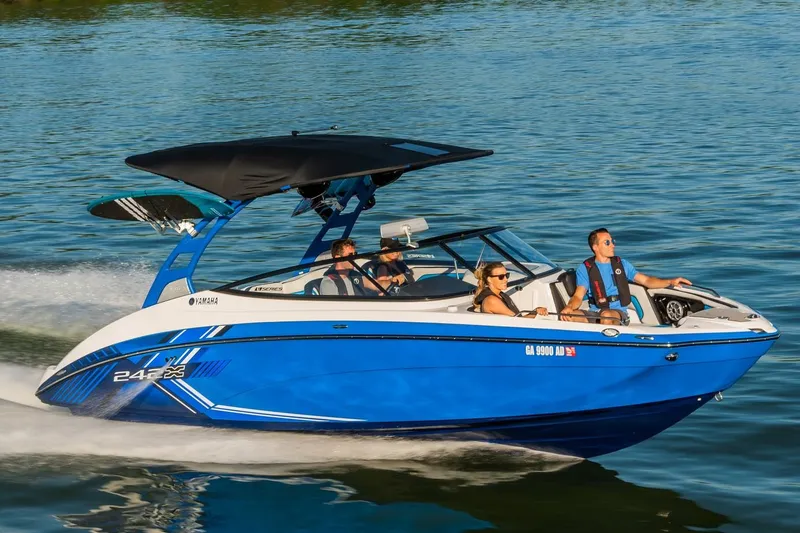 The Image of 2019 Yamaha Boats 242X E-Series, blue and white, on trailer outside dealership. - 0