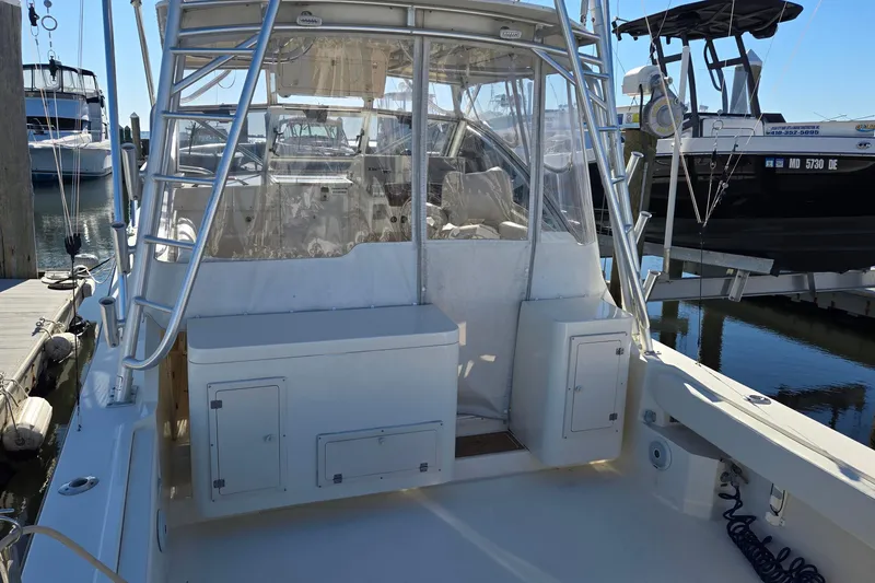 Slide: The Image of 2003 Albemarle 320 Express Fisherman boat docked, featuring a spacious deck and ladder. - 10