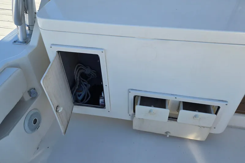 Slide: The Image of 2003 Albemarle 320 Express Fisherman boat storage compartment with open door and visible ropes. - 16