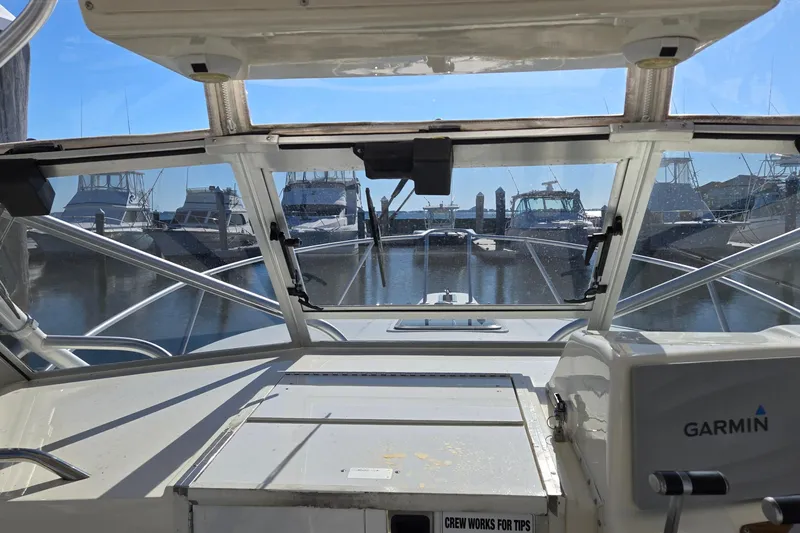 Slide: The Image of Cockpit view of 2003 Albemarle 320 Express Fisherman at marina, featuring Garmin equipment. - 17