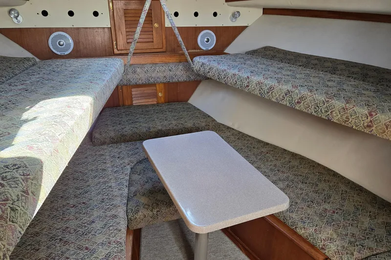 Slide: The Image of 2003 Albemarle 320 Express Fisherman cabin with patterned seating and a central table. - 9