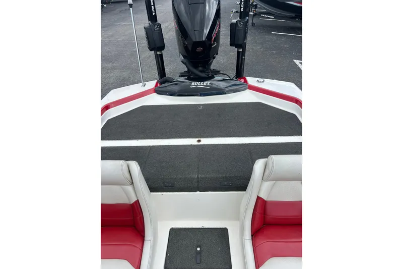 Slide: The Image of 2006 Bullet 21XD boat interior with red and white seating, black motor, and carpeted deck. - 10