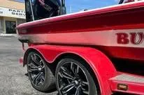 Slide: The Image of 2006 Bullet 21XD boat with red and white detailing, parked on gravel. - 4