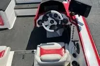 Slide: The Image of 2006 Bullet 21XD boat with red and white detailing, parked on gravel. - 5