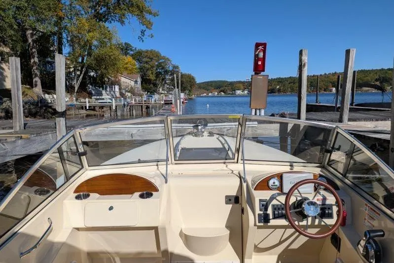Slide: The Image of 2017 Rossiter R23 boat docked by a scenic lake with clear blue skies. - 6