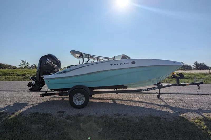 Slide: The Image of 2026 Tahoe T16 boat on trailer under clear blue sky. - 64