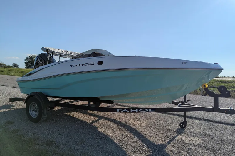 Slide: The Image of 2026 Tahoe T16 boat on trailer, parked outdoors under clear blue sky. - 65