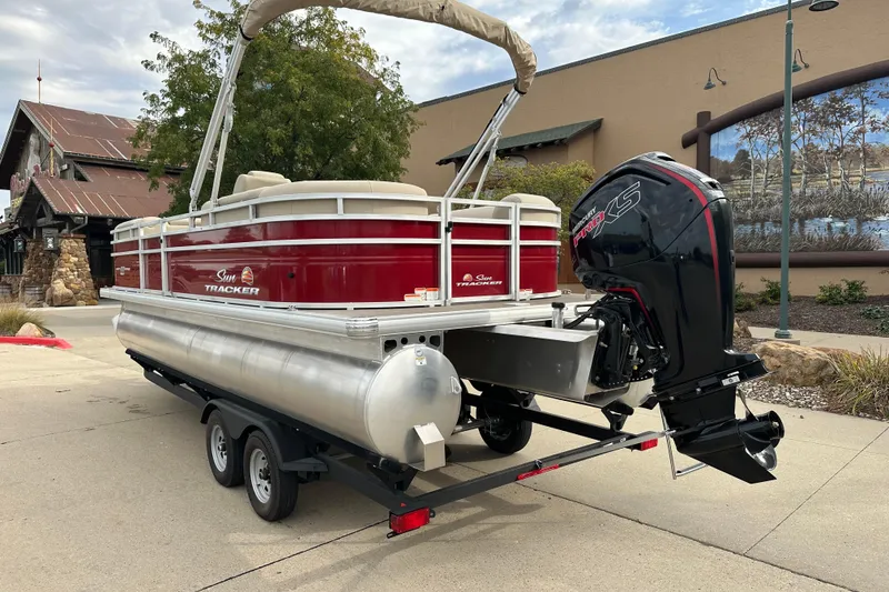 Slide: The Image of 2025 Sun Tracker Party Barge 22 DLX pontoon boat on trailer, outdoor setting. - 2