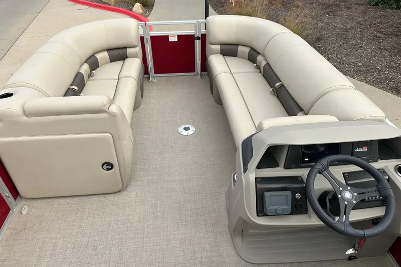 Slide: The Image of 2025 Sun Tracker Party Barge 22 DLX interior with beige seating and steering console. - 3