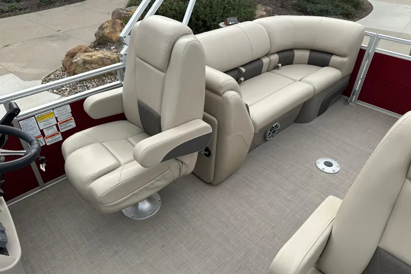Slide: The Image of 2025 Sun Tracker Party Barge 22 DLX interior with beige seating and steering wheel. - 5