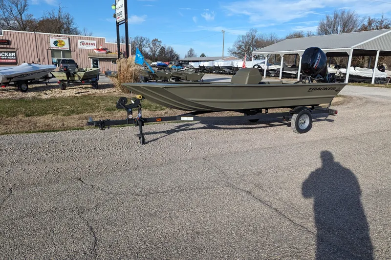 The Image of 2026 Tracker Grizzly 1648 SC boat on trailer at dealership, sunny day. - 26