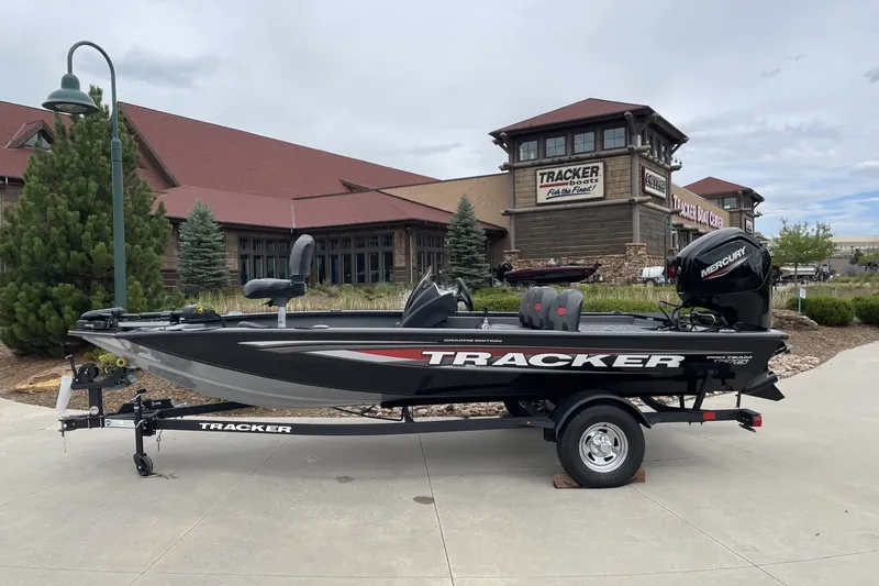 The Image of 2026 Tracker Pro Team 175 Crappie Edition boat displayed outdoors near a showroom. - 0