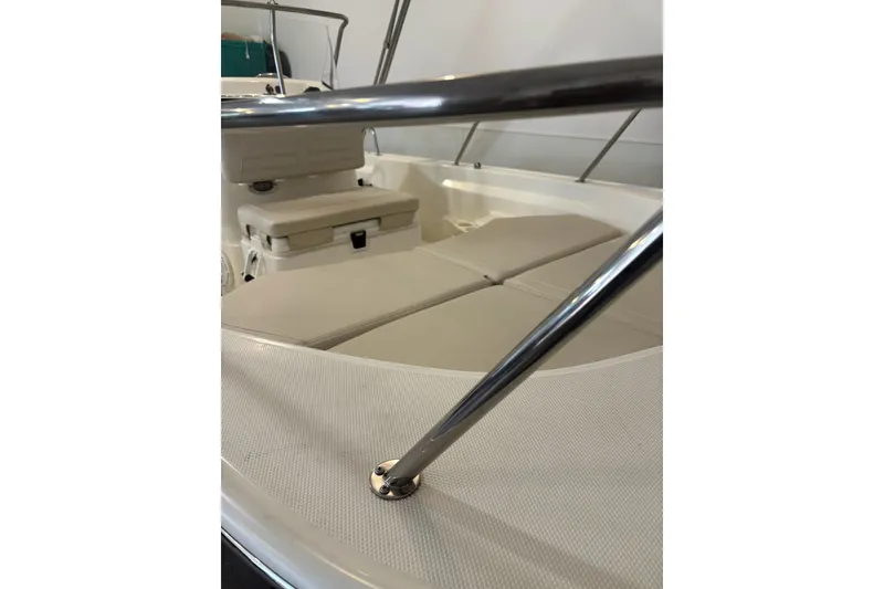 Slide: The Image of 2023 Boston Whaler 170 Montauk interior with cushioned seating and stainless steel railing. - 3