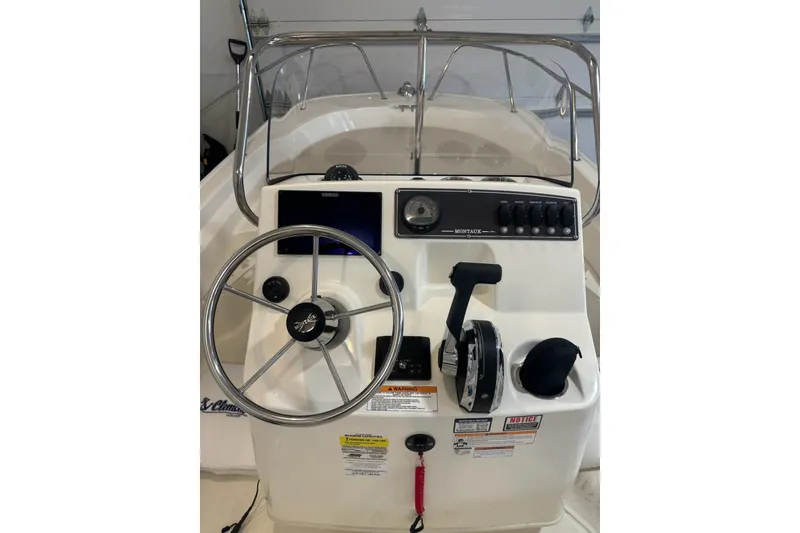 Slide: The Image of 2023 Boston Whaler 170 Montauk boat console with steering wheel and controls. - 7