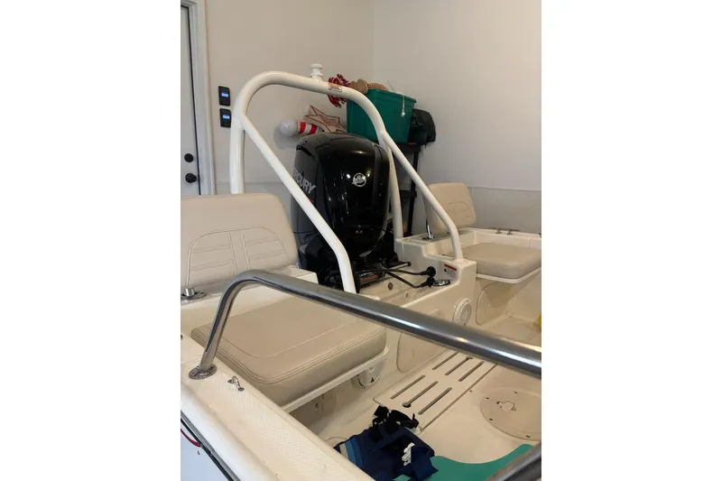 Slide: The Image of 2023 Boston Whaler 170 Montauk boat interior with Mercury engine in a garage. - 8