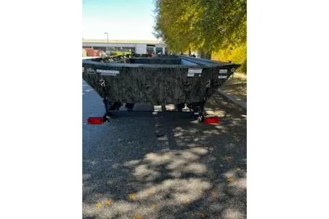 Slide: The Image of 2026 Tracker Grizzly 1754 Utility boat on a street, surrounded by trees. - 3