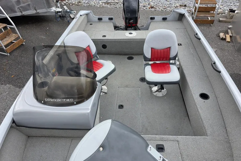 Slide: The Image of 2005 TRACKER BOATS Targa V16 Side Console with red and gray seating, docked outdoors. - 11
