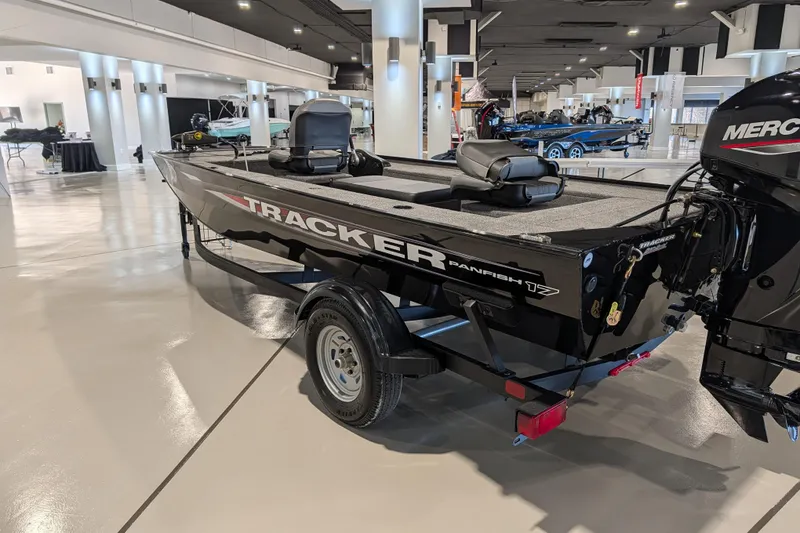 Slide: The Image of 2025 Tracker Panfish 17 boat displayed indoors, featuring sleek design and modern outboard motor. - 38