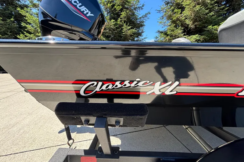 Slide: The Image of 2026 Tracker Bass Tracker Classic XL boat with Mercury engine, parked outdoors. - 30