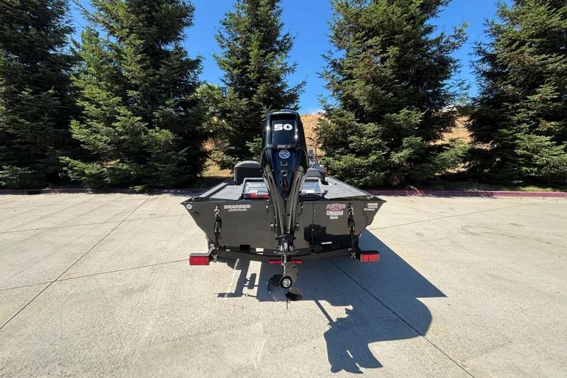 Slide: The Image of 2026 Tracker Bass Tracker Classic XL boat with motor, parked outdoors near trees. - 16