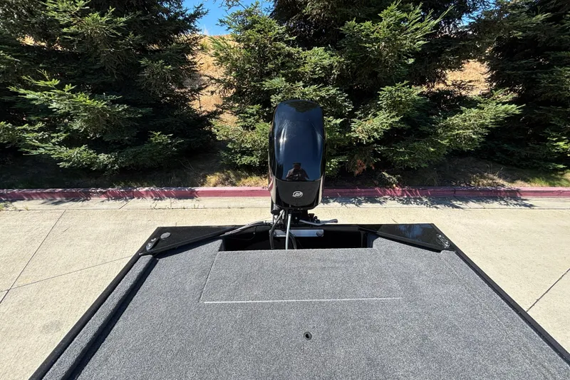 Slide: The Image of 2026 Tracker Bass Tracker Classic XL boat with motor, parked near trees. - 12