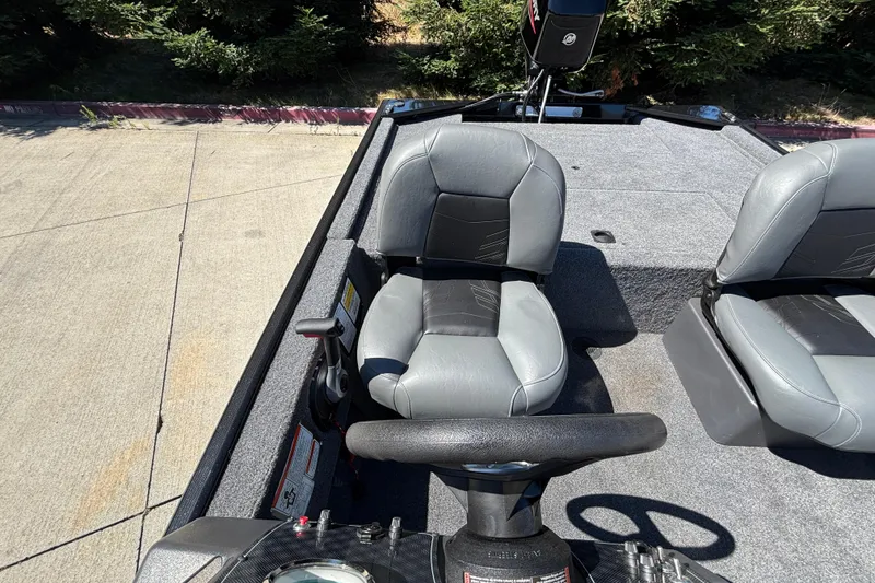 Slide: The Image of 2026 Tracker Bass Tracker Classic XL boat interior with gray seating and steering wheel. - 14