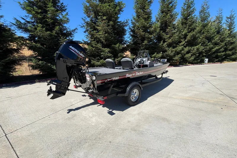 Slide: The Image of 2026 Tracker Bass Tracker Classic XL boat with Mercury engine, parked outdoors. - 7