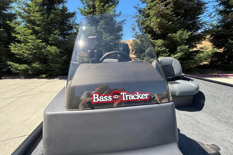 Slide: The Image of 2026 Tracker Bass Tracker Classic XL boat with windshield, parked outdoors. - 23