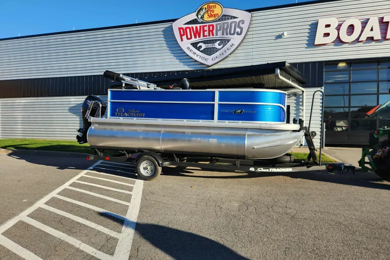 The Image of 2026 Sun Tracker Party Barge 16 DLX pontoon boat on trailer outside service center. - 0