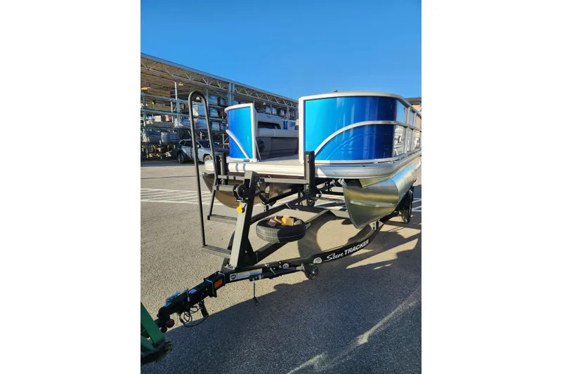 Slide: The Image of 2026 Sun Tracker Party Barge 16 DLX pontoon boat on trailer, parked outdoors. - 3