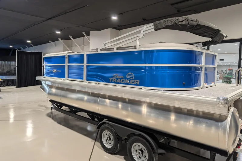 Slide: The Image of 2026 Sun Tracker Party Barge 20 DLX pontoon boat in showroom, blue exterior. - 69