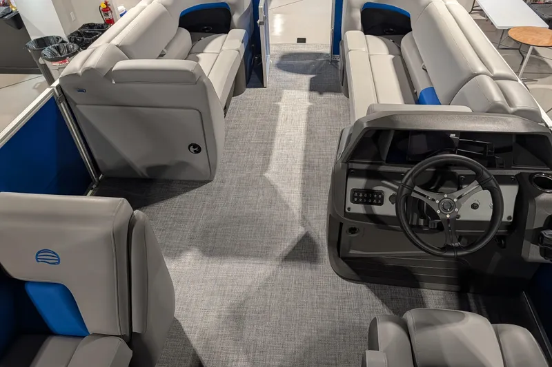 Slide: The Image of 2026 Sun Tracker Party Barge 20 DLX interior with gray seating and steering console. - 77