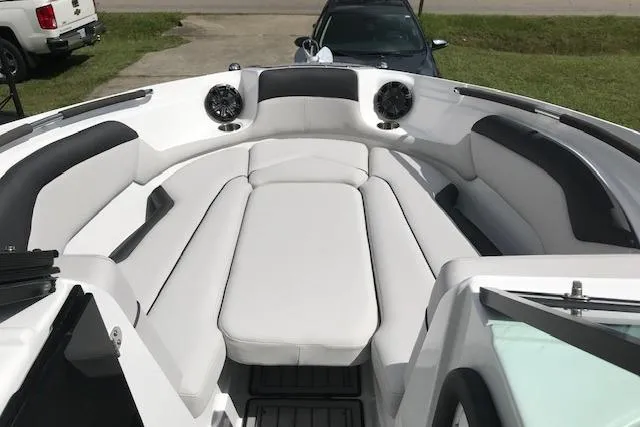 Slide: The Image of 2018 Rinker 29QX boat interior with white seating and speakers. - 14