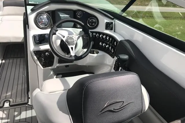 Slide: The Image of 2018 Rinker 29QX boat cockpit with steering wheel and control panel. - 16