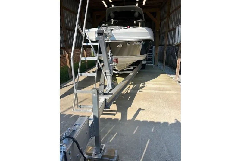 Slide: The Image of 2018 Rinker 29QX boat on trailer in storage facility. - 2