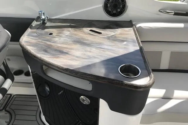 Slide: The Image of 2018 Rinker 29QX boat interior with sleek countertop and built-in cup holder. - 18