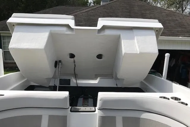 Slide: The Image of 2018 Rinker 29QX boat with open engine compartment, showcasing storage and seating area. - 7
