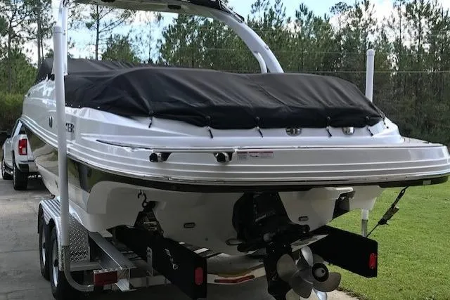 Slide: The Image of 2018 Rinker 29QX boat on trailer, covered, parked outdoors. - 19