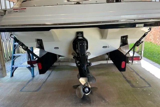 Slide: The Image of 2018 Rinker 29QX boat stern with propeller and trailer in a garage. - 4