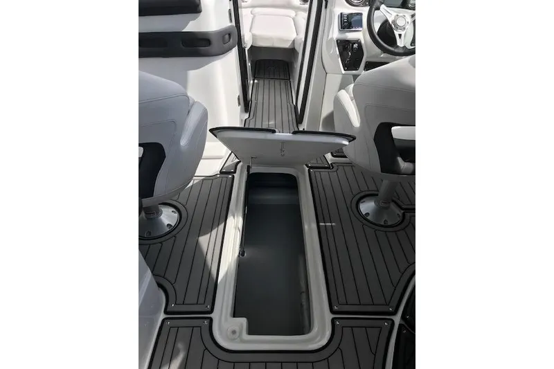 Slide: The Image of 2018 Rinker 29QX boat interior with open storage compartment and sleek seating. - 10