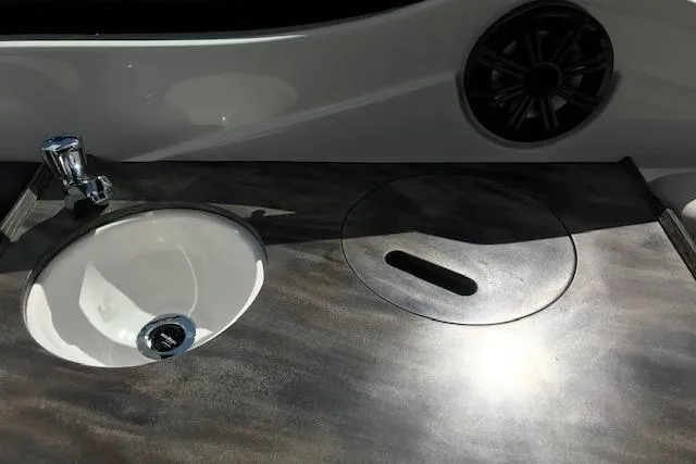 Slide: The Image of 2018 Rinker 29QX boat sink and countertop with integrated speaker. - 17