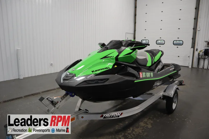 Slide: The Image of 2023 Kawasaki 310LX-S Ultra jet ski in green and black on a trailer indoors. - 1