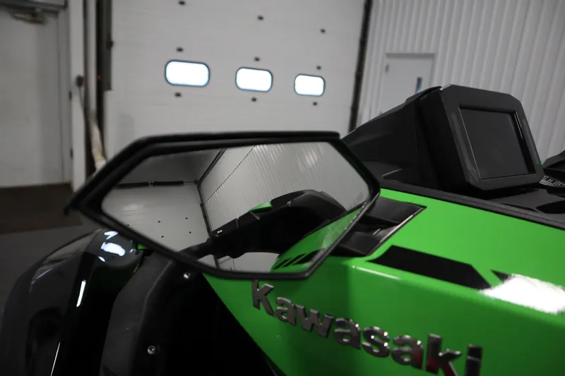 Slide: The Image of 2023 Kawasaki 310LX-S Ultra, green exterior, side mirror view in a garage setting. - 11
