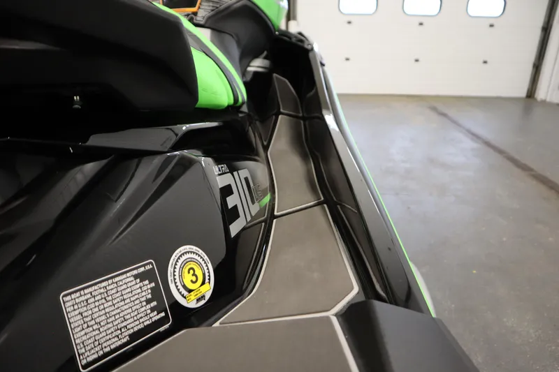 Slide: The Image of 2023 Kawasaki 310LX-S Ultra jet ski, close-up of sleek black and green design. - 23