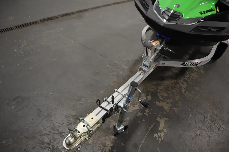 Slide: The Image of 2023 Kawasaki 310LX-S Ultra on trailer, close-up of hitch and front section. - 28