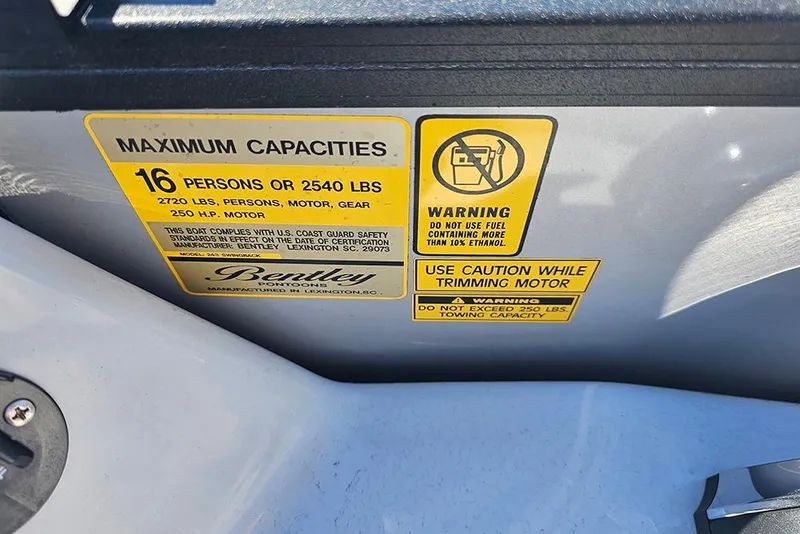 Slide: The Image of Capacity and warning labels on 2023 Bentley Pontoons 243 Legacy Swingback boat. - 15